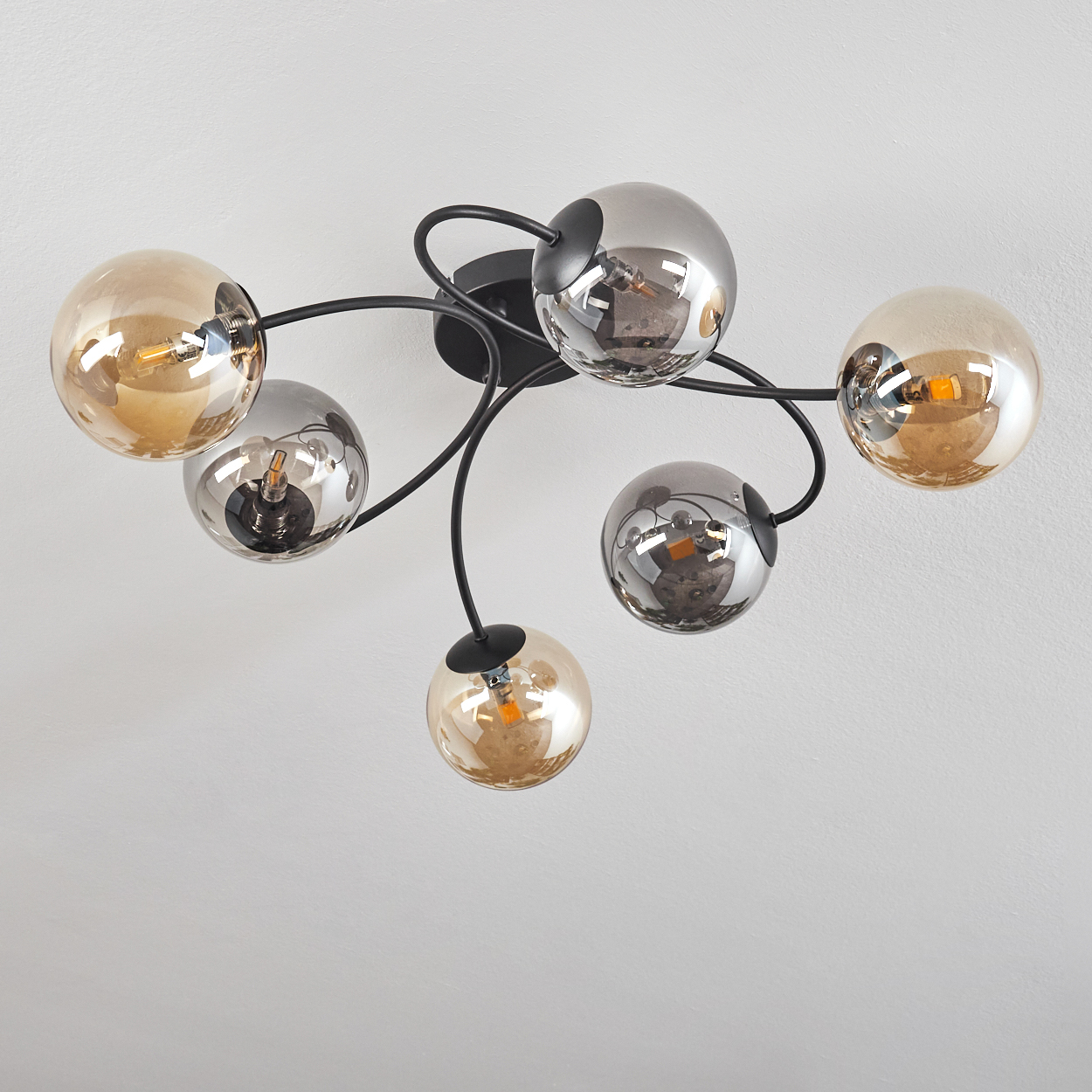 Deckenlampe mit sechs Lichtern, drei silbernen und drei goldenen. Das Licht ist aus.