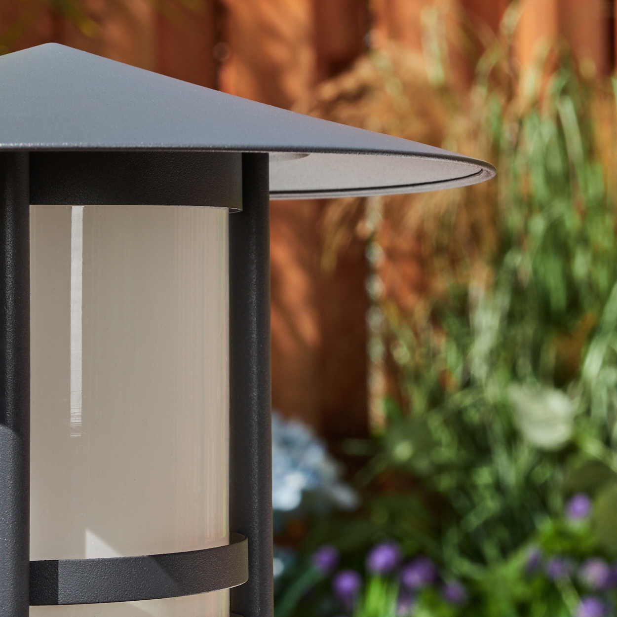 Nahaufnahme einer Außenlaterne mit zylindrischem weißem Licht und flachem Dach.