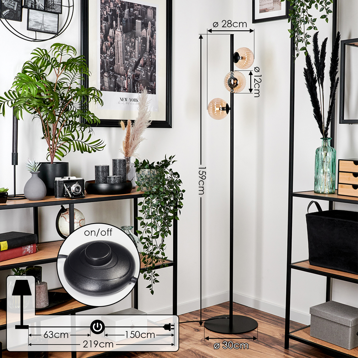 Wohnzimmer mit hoher schwarzer Lampe, New York Poster, Regalen, Pflanzen und Fußschalter.