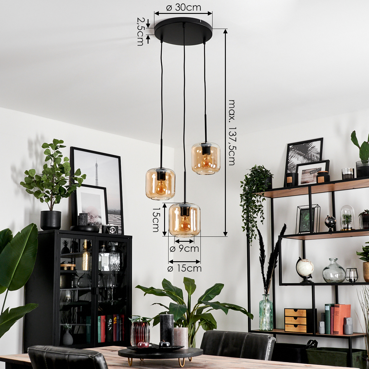 Drei bernsteinfarbene Glas-Pendelleuchten hängen über einem Tisch mit Dekorationen in einem Esszimmer.