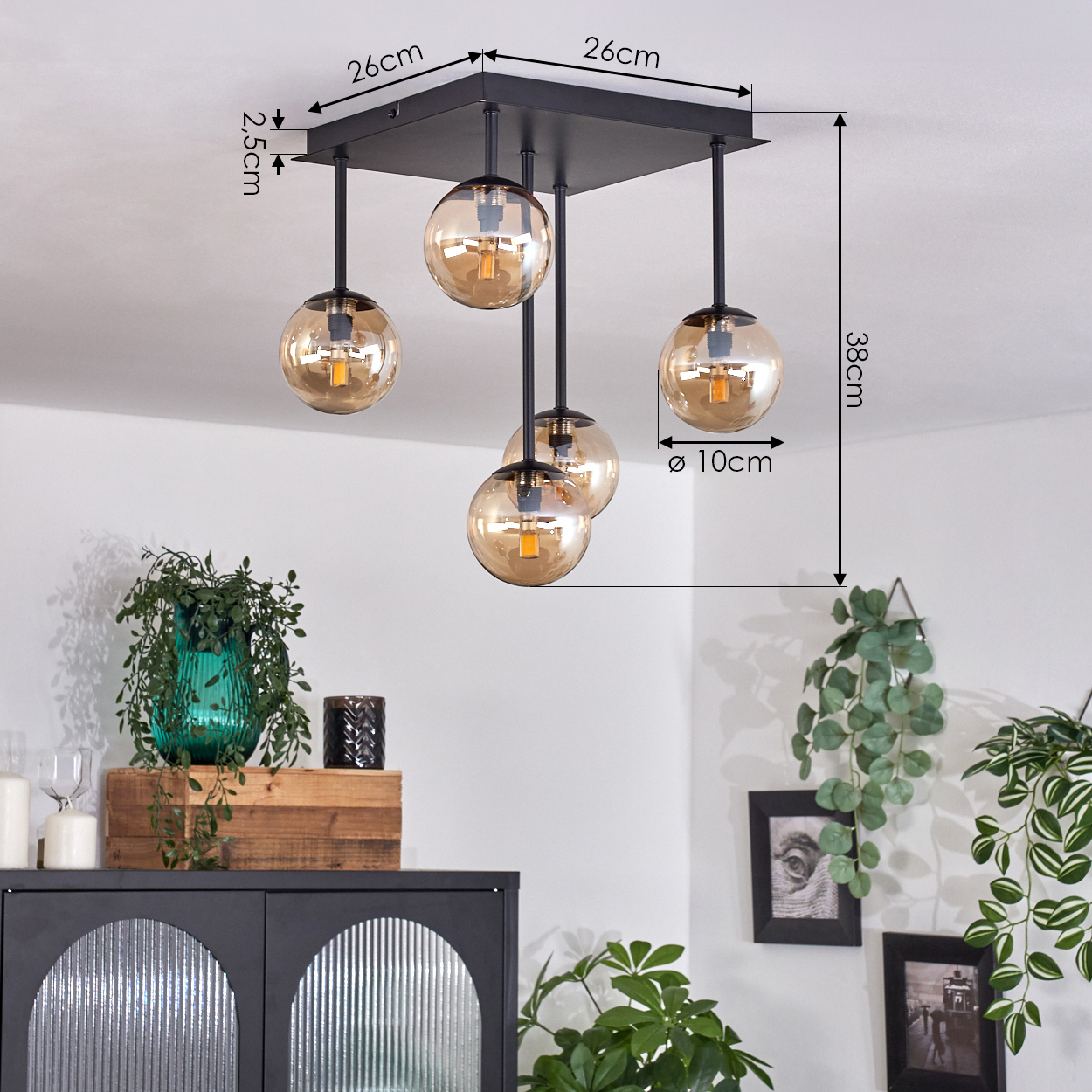 Schwarze Deckenlampe mit bernsteinfarbenen Glaskugeln. Pflanzen und Deko im Raum.