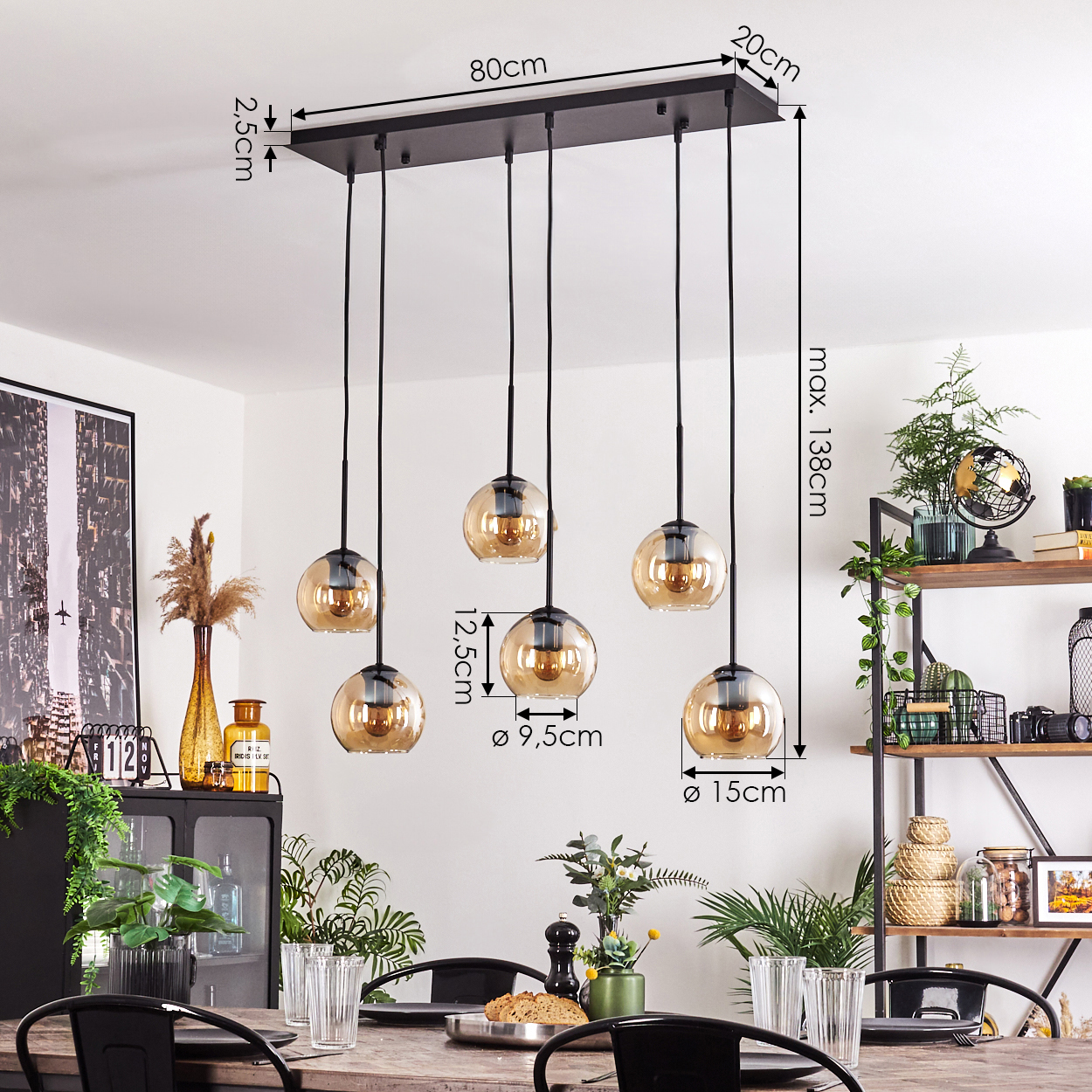 Esszimmer mit Hängeleuchten. Sechs bernsteinfarbene Glaskugelleuchten hängen über einem Holztisch. Schwarze Metallregale im Hintergrund.