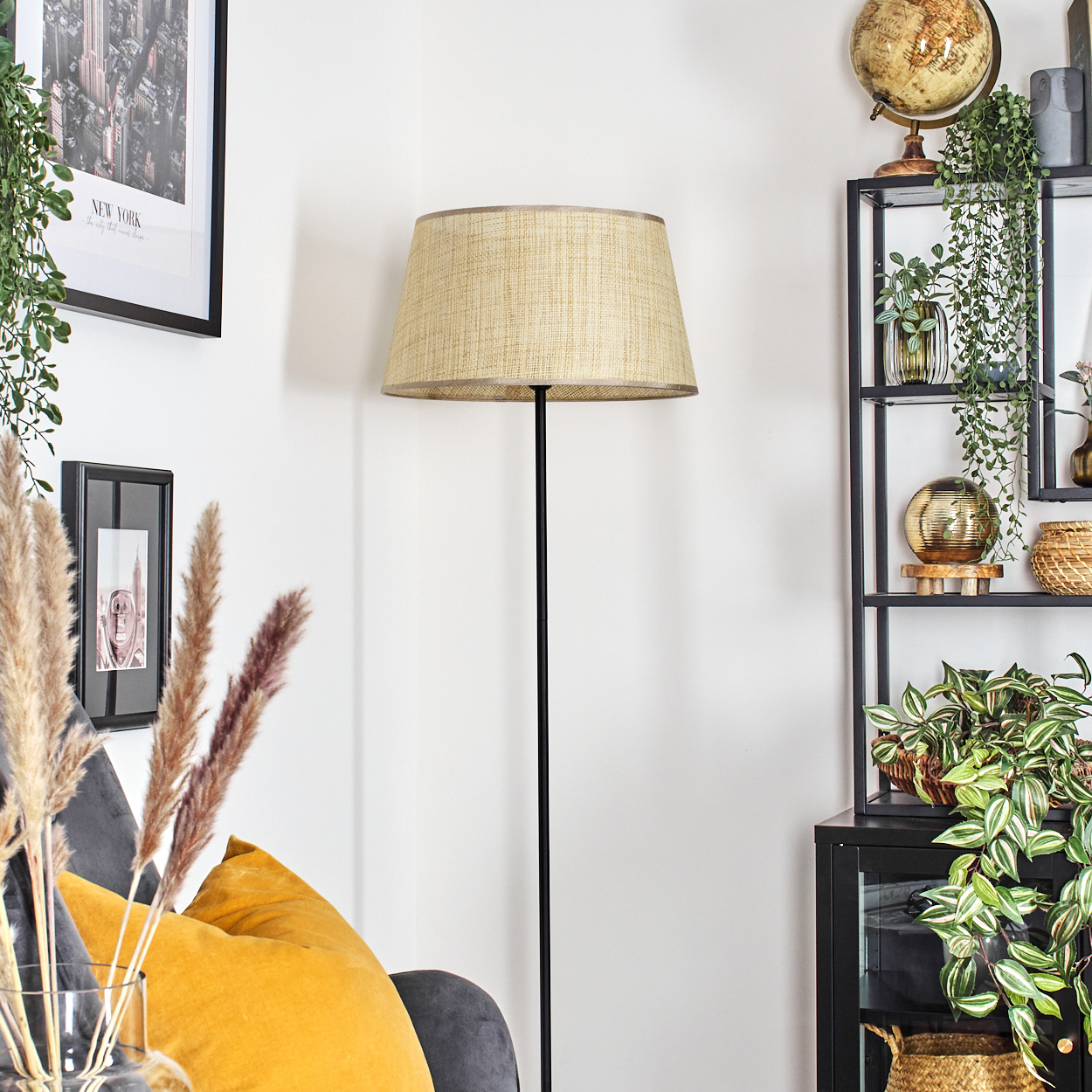 Wohnzimmer mit Stehlampe, Stuhl, Pflanzen und Dekorationsartikeln. Die Lampe hat einen beigen Schirm.