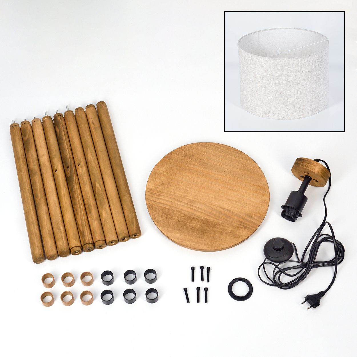 Zerlegte Holz-Stativlampenteile, einschließlich Beine, Schirm und Basis, auf weißer Oberfläche.
