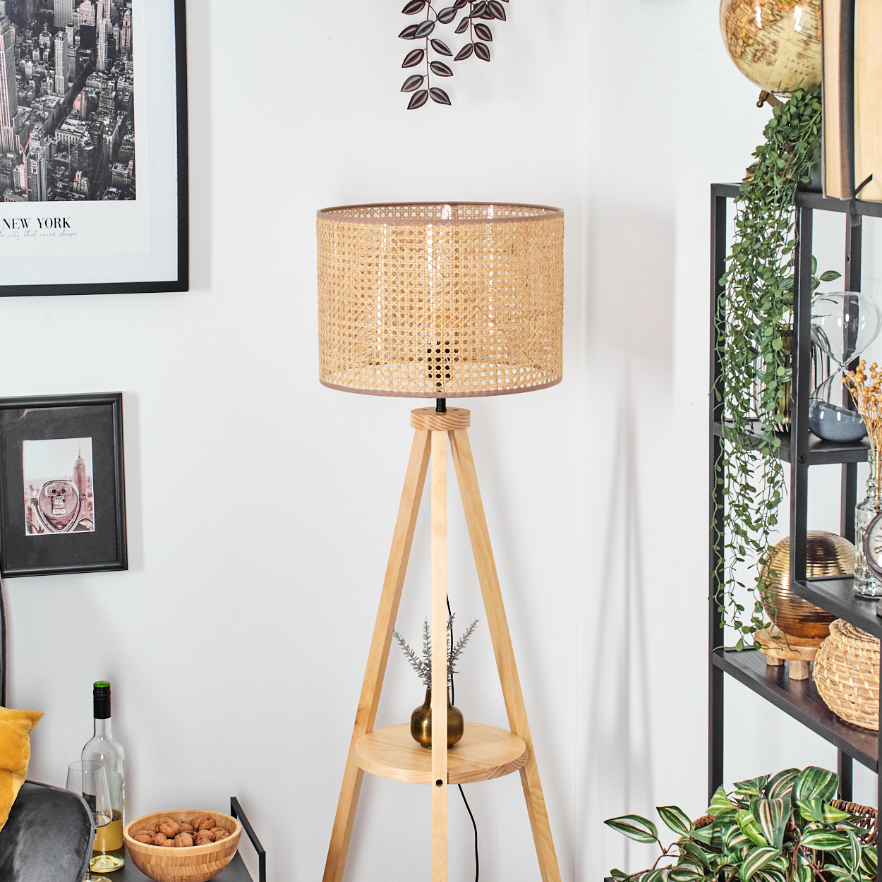 Holz-Stativlampe mit gewebtem Lampenschirm. Raum mit Dekoration und Globus.
