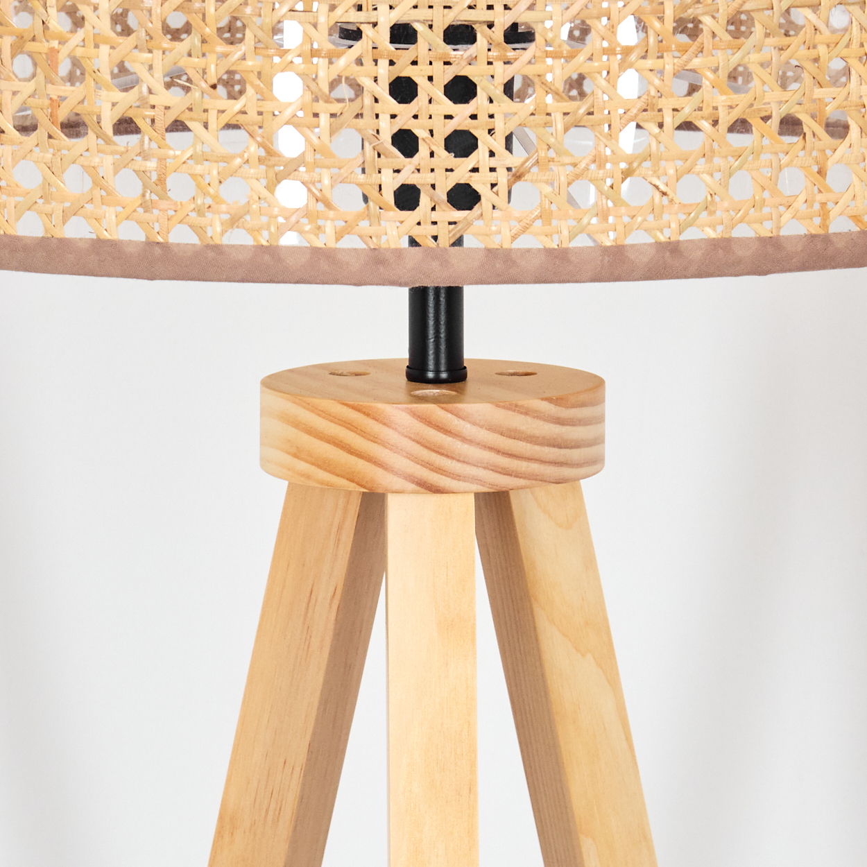 Holzlampenfuß mit Rattanschatten. Braune Verkleidung. Weißer Hintergrund. Nahansicht.