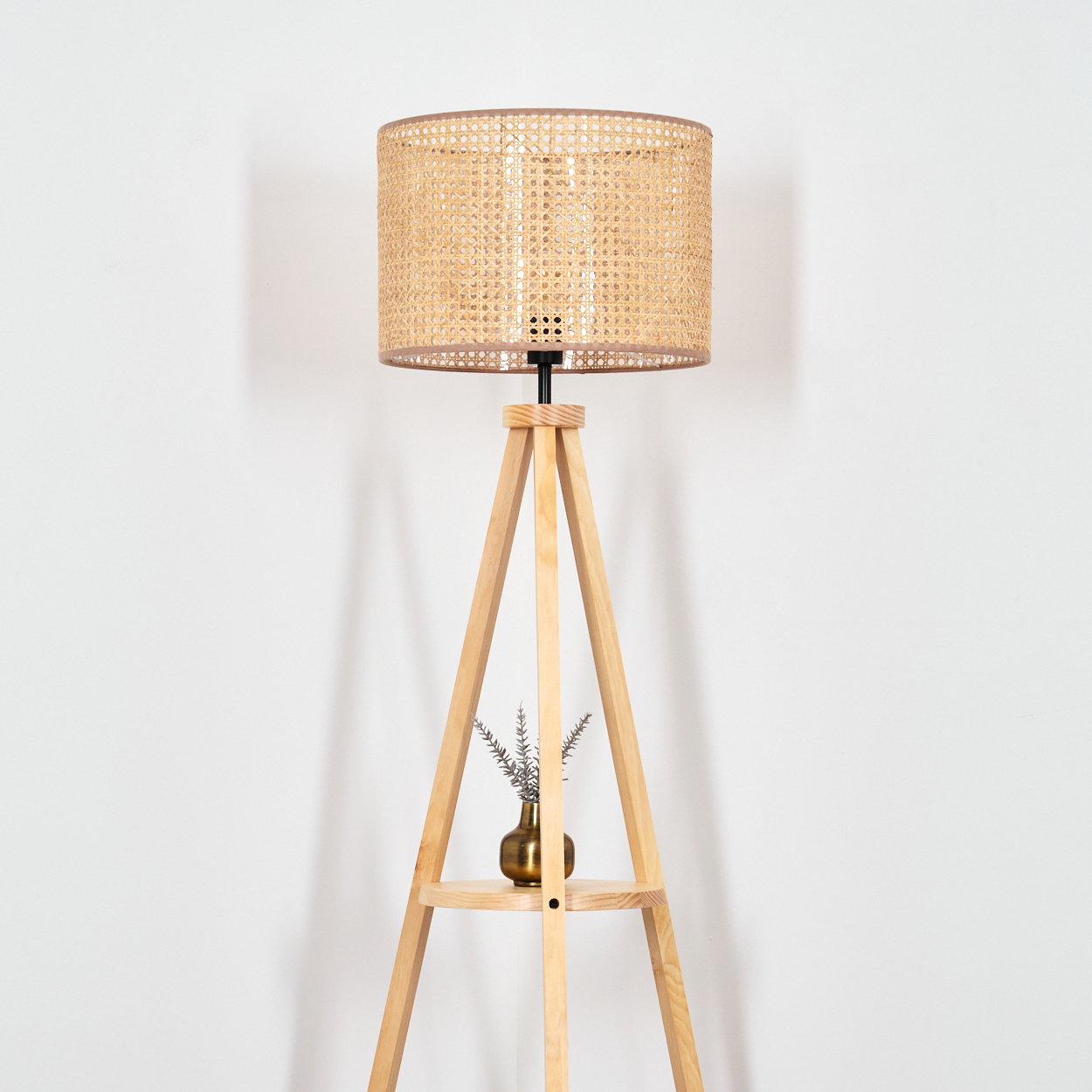 Holz-Dreibein-Lampe. Rattan-Schirm, kleine Vase mit Pflanze, goldene Vase. Weißer Hintergrund.