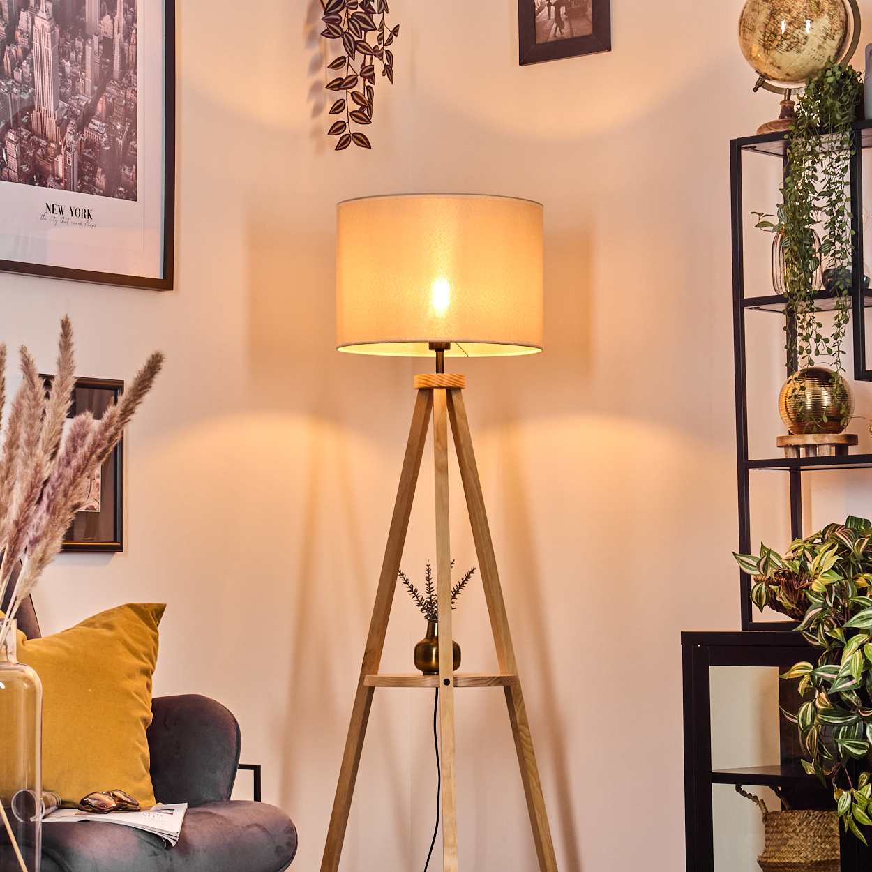 Wohnzimmerszene bei Nacht, mit einer beleuchteten Stehlampe aus Holz.
