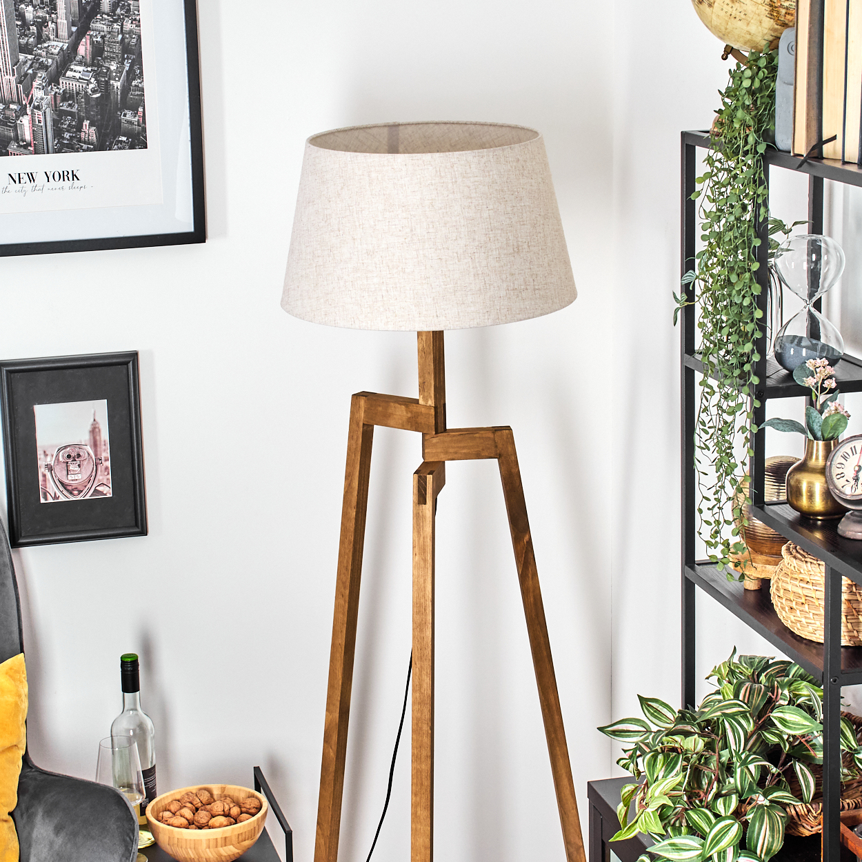 Stehlampe aus Holz mit beigem Lampenschirm in einem Wohnzimmer.