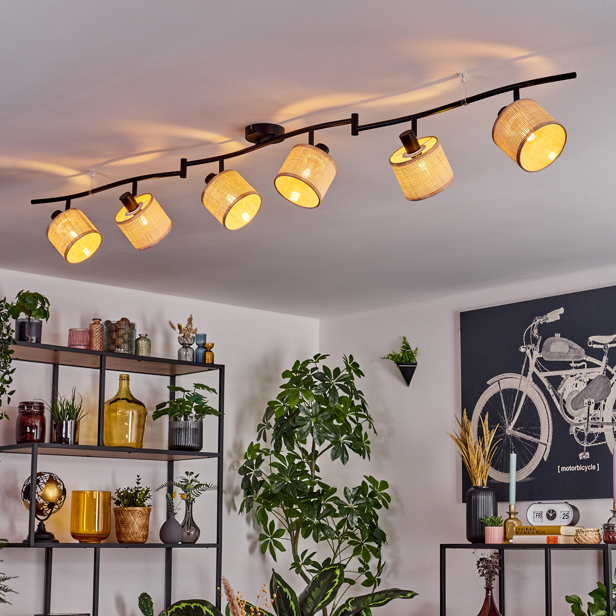 An der Decke montierte Schienenbeleuchtung mit mehreren gewebten Lampenschirmen, in einem Wohnzimmer.