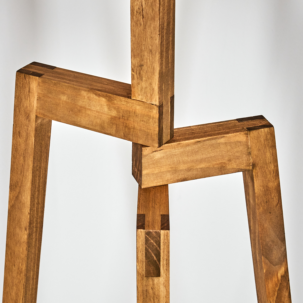 Nahaufnahme des Holzlampenfußes. Die Beine sind oben verbunden.