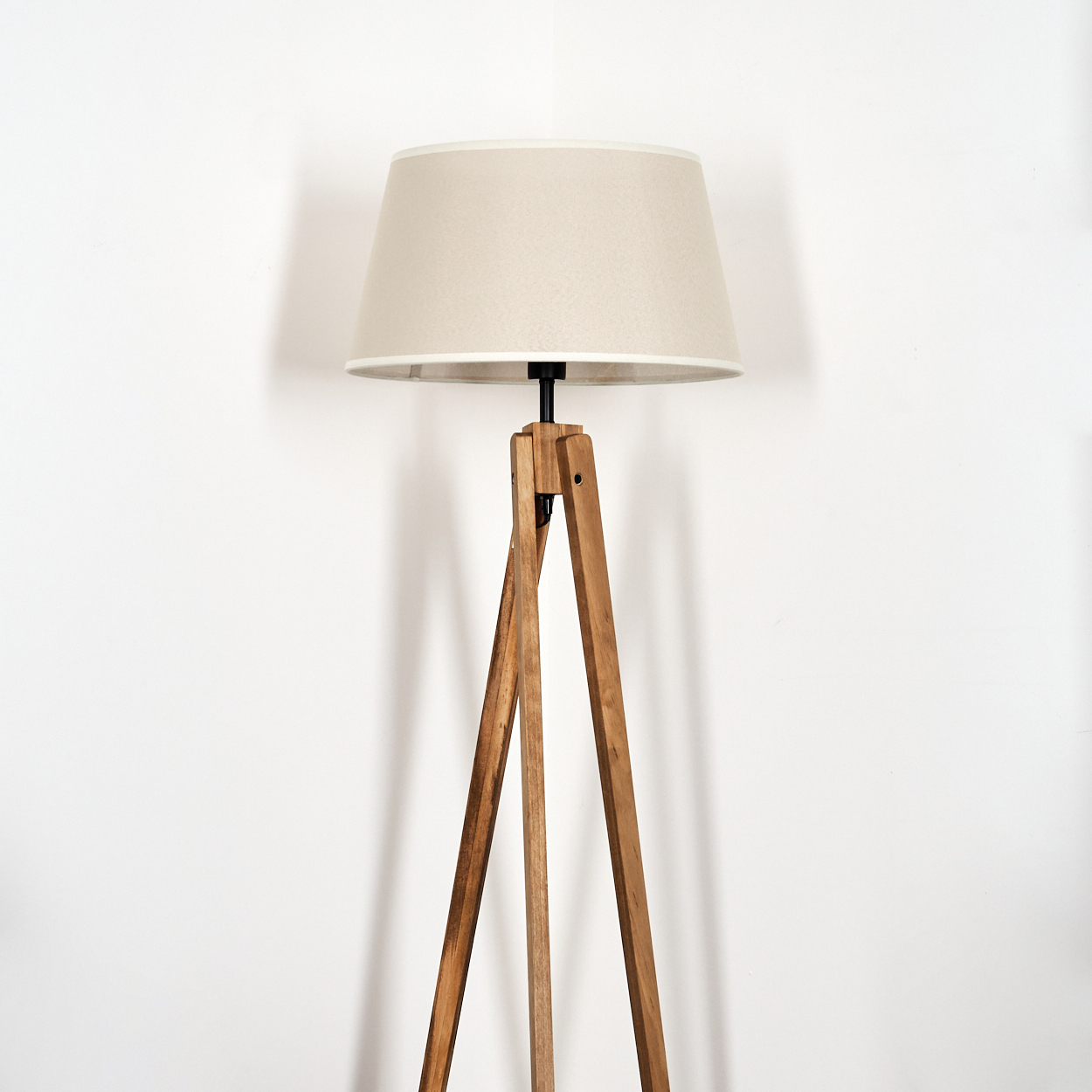 Stativlampe mit beigem Schirm. Weißer Hintergrund. Vorderansicht.