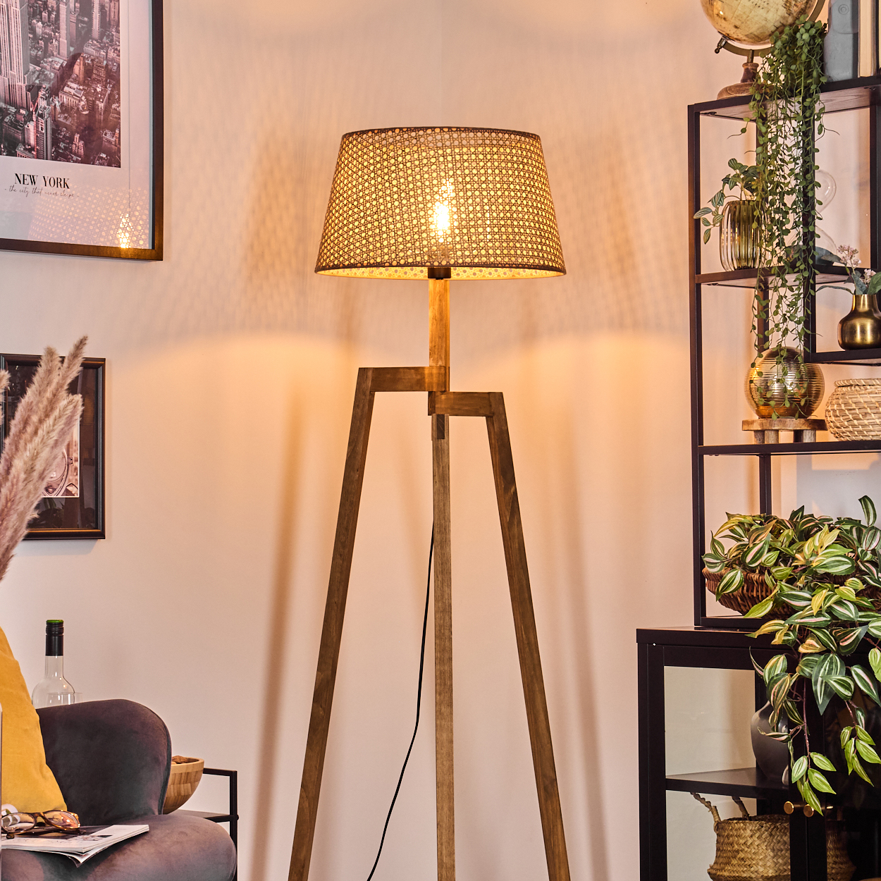 Holz-Stativ-Stehlampe mit gewebtem Schirm, beleuchtet. Inneneinrichtung. Weiße Wand und Dekor.