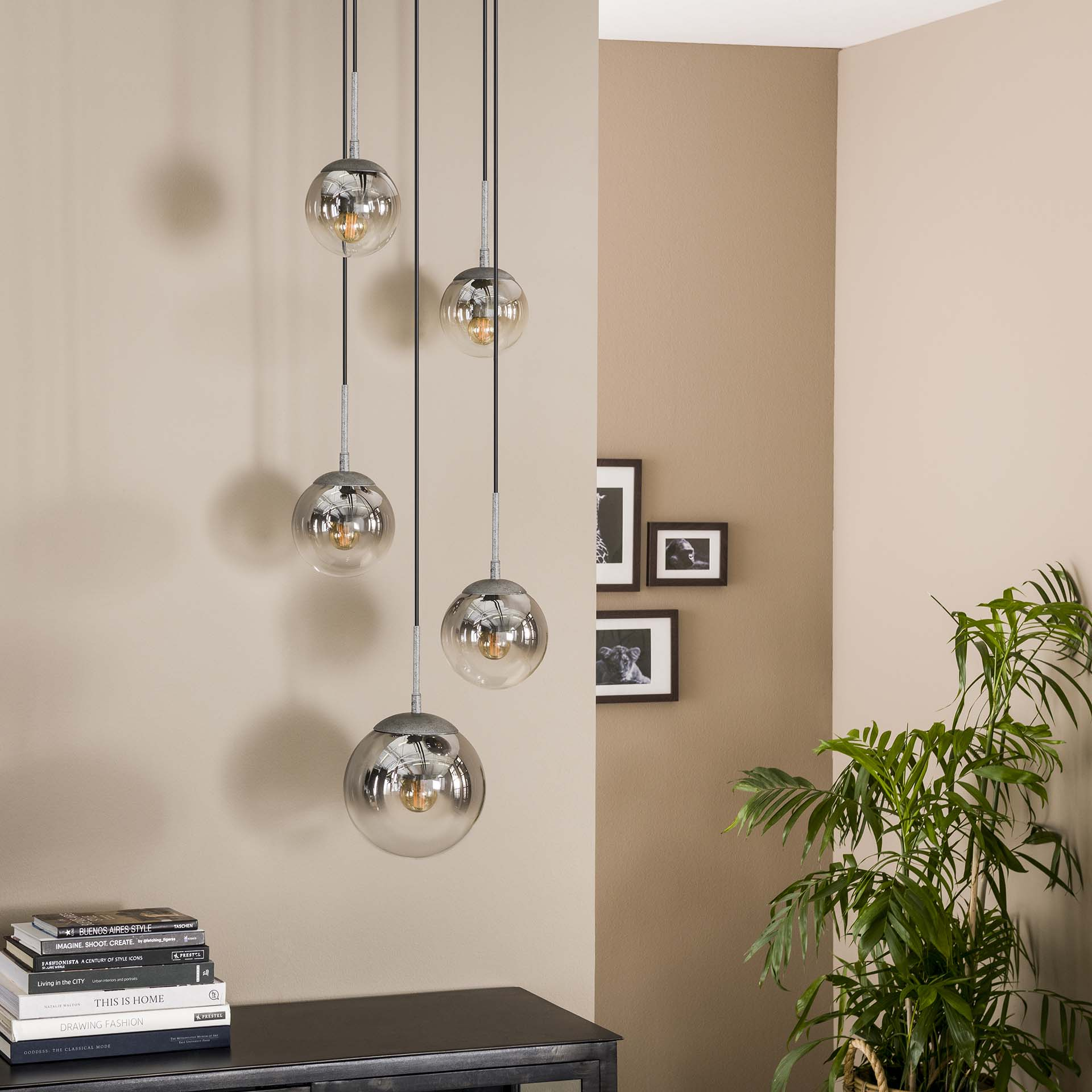 Fünf hängende Kugellampen mit Chromdetails und neutralem Wandhintergrund.