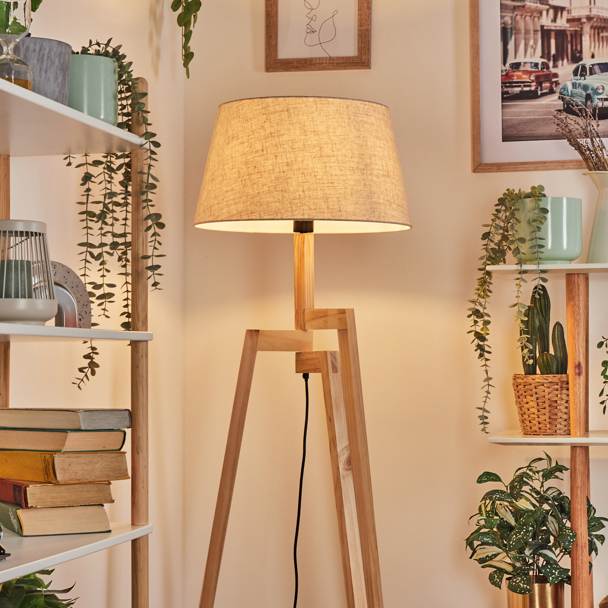 Holz-Stehleuchte mit Stoffschirm, in der Nähe von Regalen mit Pflanzen und Dekoration.