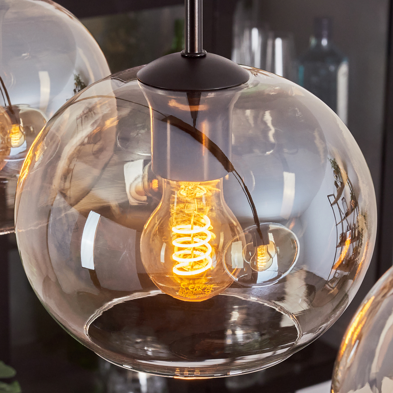 Nahaufnahme einer Glasglühbirne mit orangefarbenem Glühfaden.
