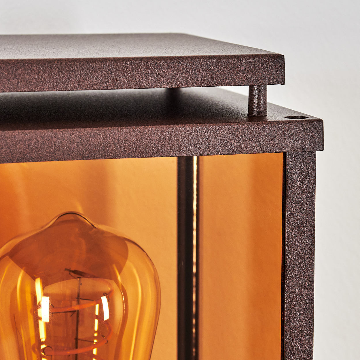 Nahaufnahme einer Lampe mit kupferfarbenem Metallrahmen und Glühbirne.