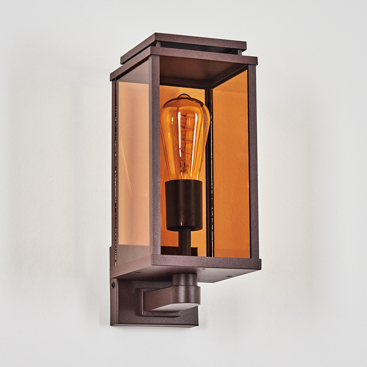 Bronze-Außenwandleuchte mit leuchtender Glühbirne, vor weißem Hintergrund.