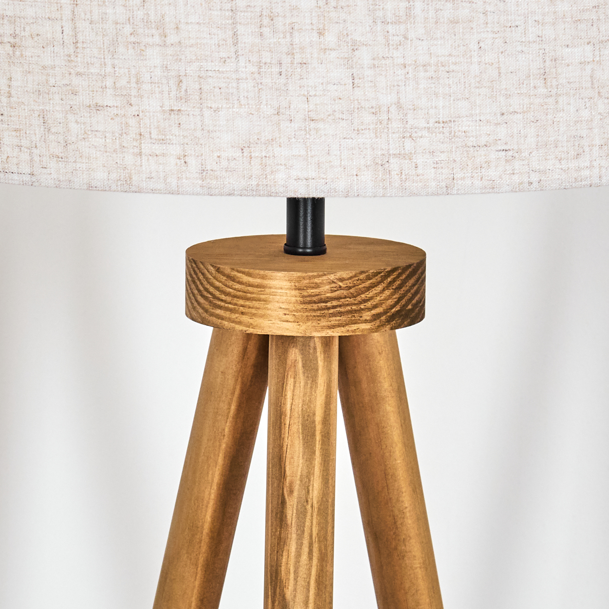 Holz-Stativ-Lampenfuß mit hellem Schirm, vor weißem Hintergrund.