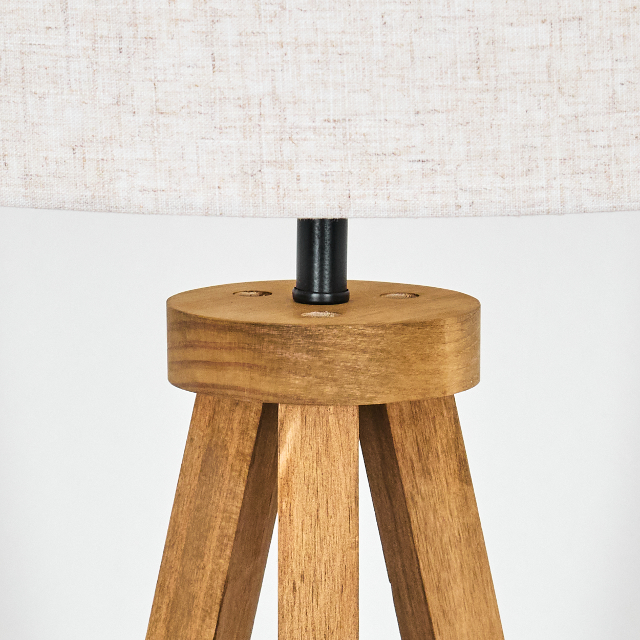 Holz-Stativ-Lampenfuß mit Leinen-Lampenschirm, vor weißem Hintergrund.