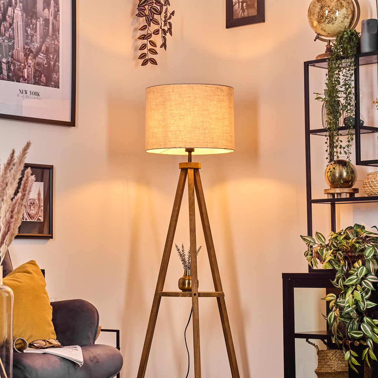 Wohnzimmer mit Holz-Dreibein-Lampe, Dekoration und Pflanzen.