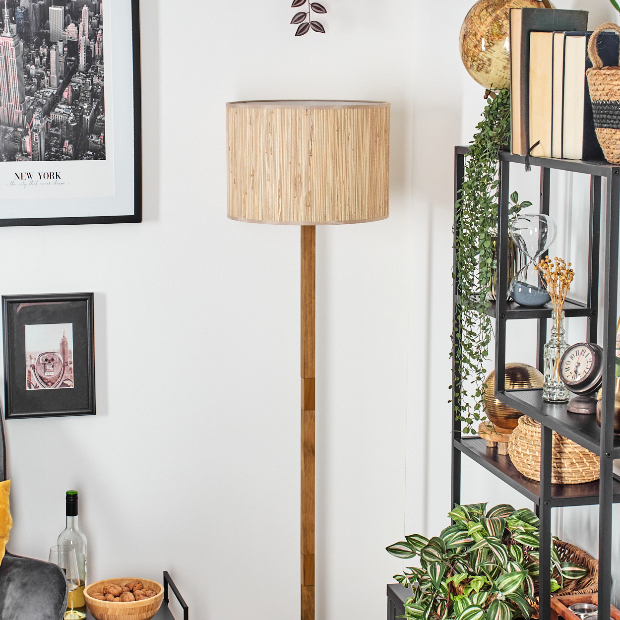 Wohnzimmerszene mit Holz-Stehlampe und Dekoration.