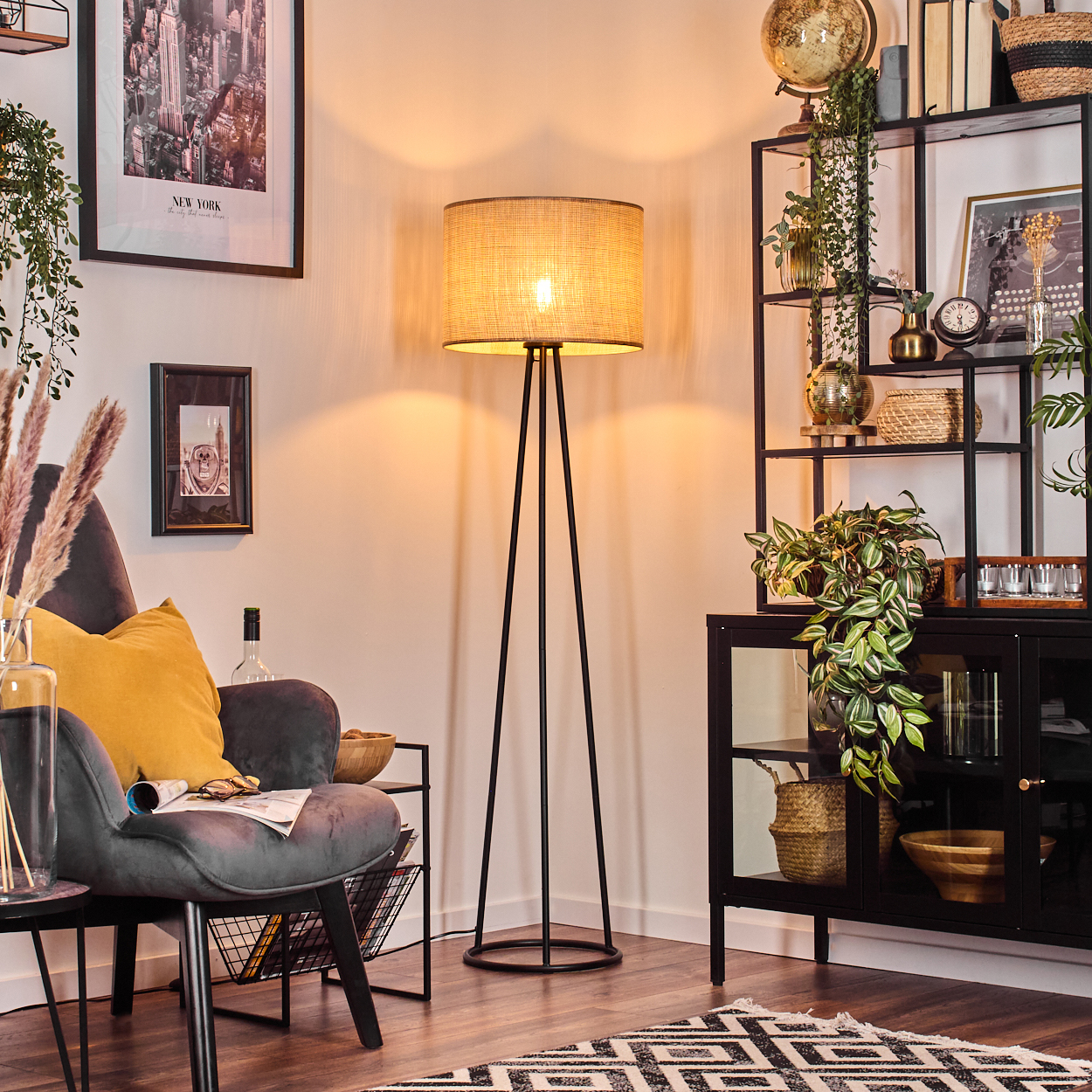 Wohnzimmer mit Stehlampe, Regalen und Dekoration.