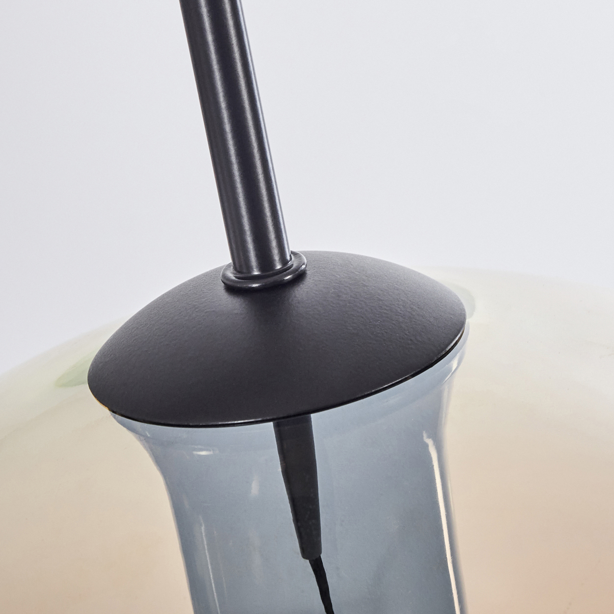 Nahaufnahme einer schwarzen Metall-Lampenfassung. Eine Glühbirne ist in einem Glaskolben montiert.