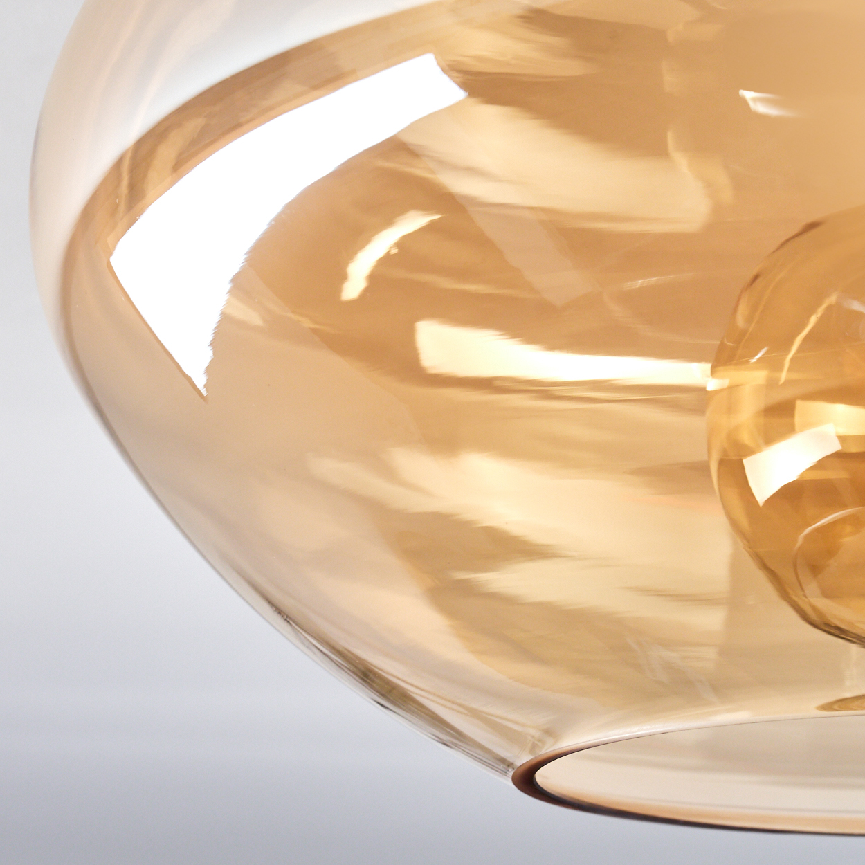Nahaufnahme einer Glaskugel mit Edison-Glühbirne darin.