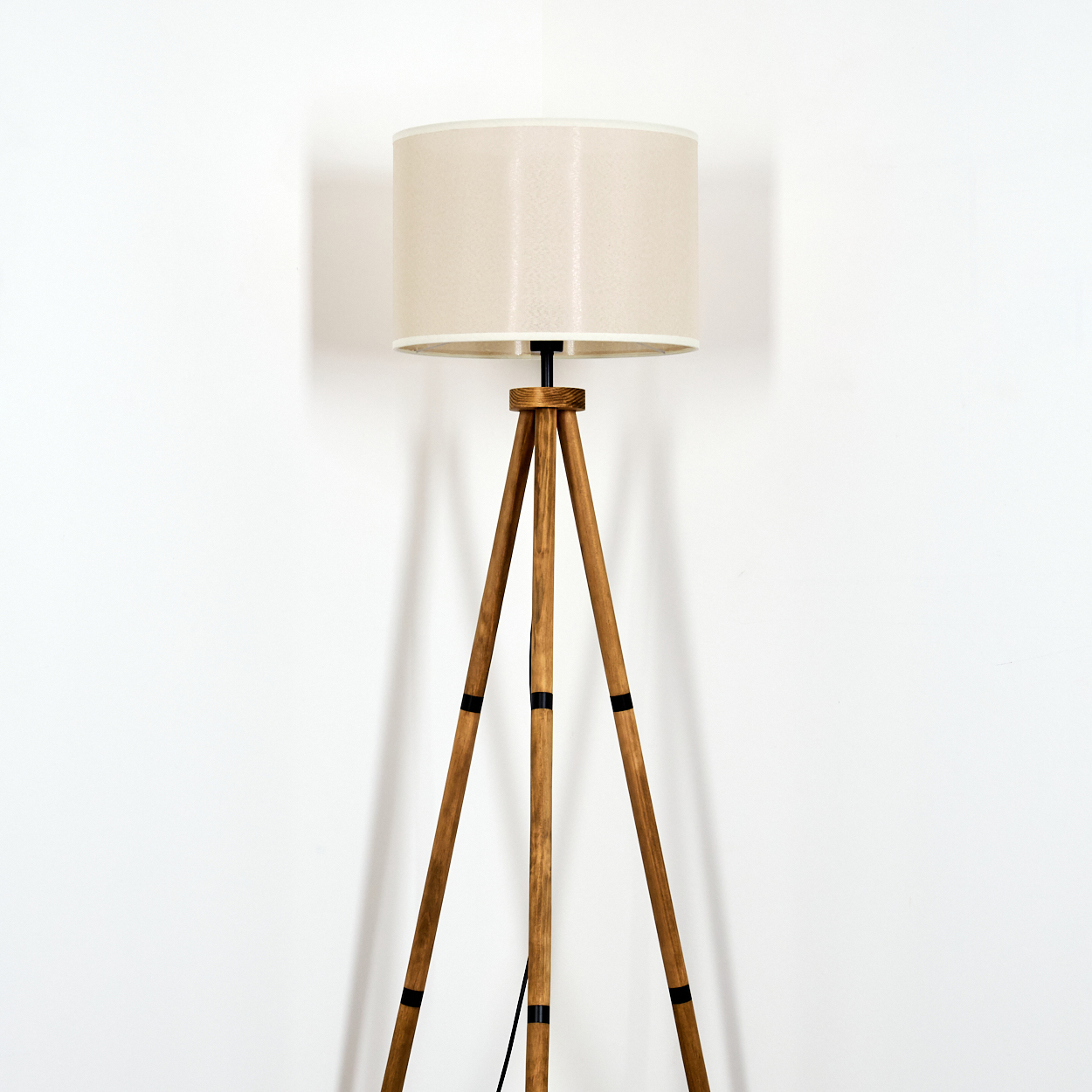 Stehlampe aus Holz mit cremefarbenem Lampenschirm.