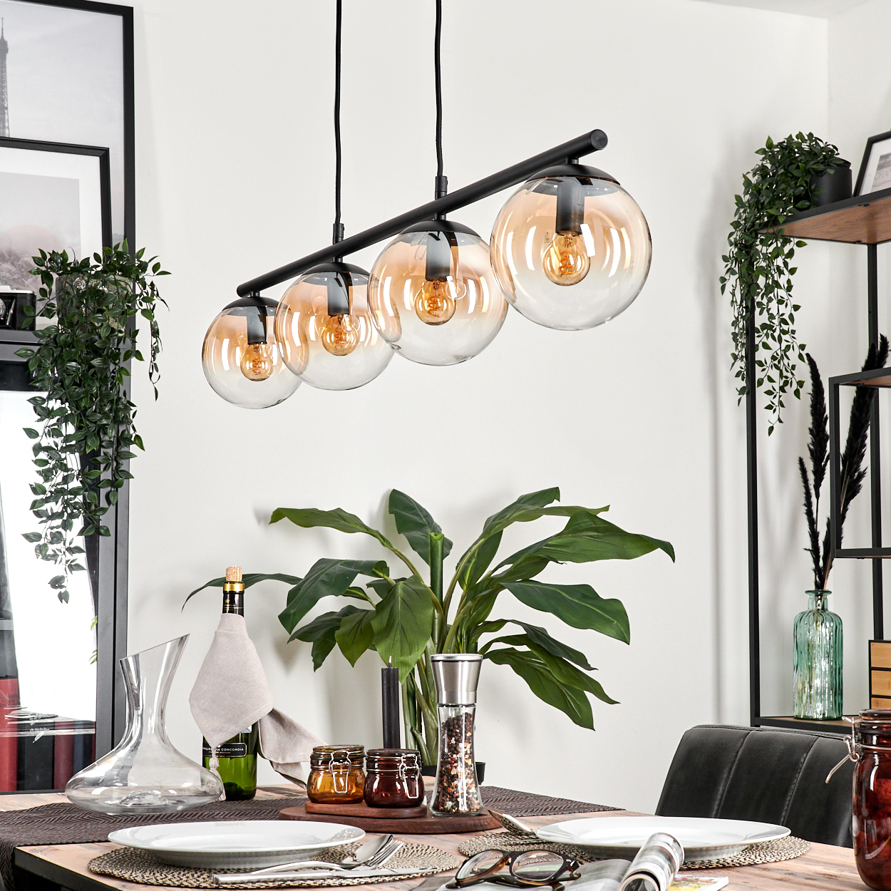 Esszimmer mit vier Amber-Glaskugel-Hängeleuchten und Dekoration.