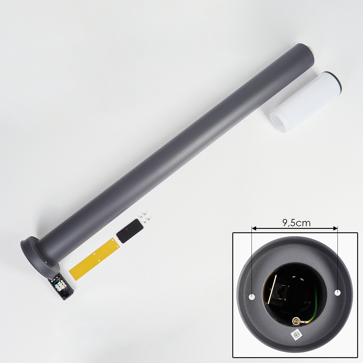 Zerlegte Lampenteile: ein grauer Mast, ein weißer Zylinder und ein schwarzer Sockel mit elektrischen Komponenten.