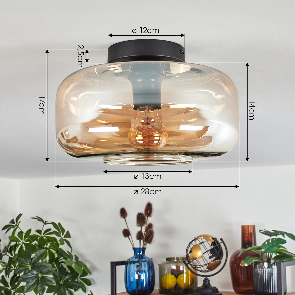Deckenlampe mit bernsteinfarbenem Glasschirm und sichtbarer Glühbirne, mit Abmessungen: 17cm Höhe, 28cm Durchmesser.