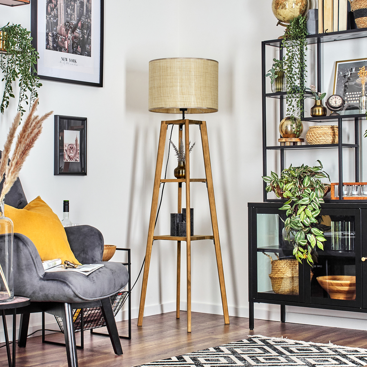Ein gut beleuchteter Raum mit einer hölzernen Stehlampe mit Stoffschirm und einem Sofa mit gelbem Kissen.
