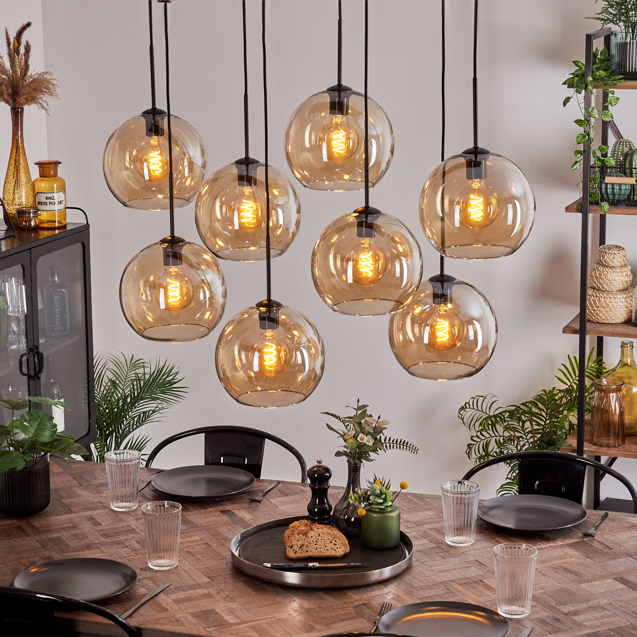 Esszimmer mit Holztisch und Kronleuchter mit Glaskugeln.