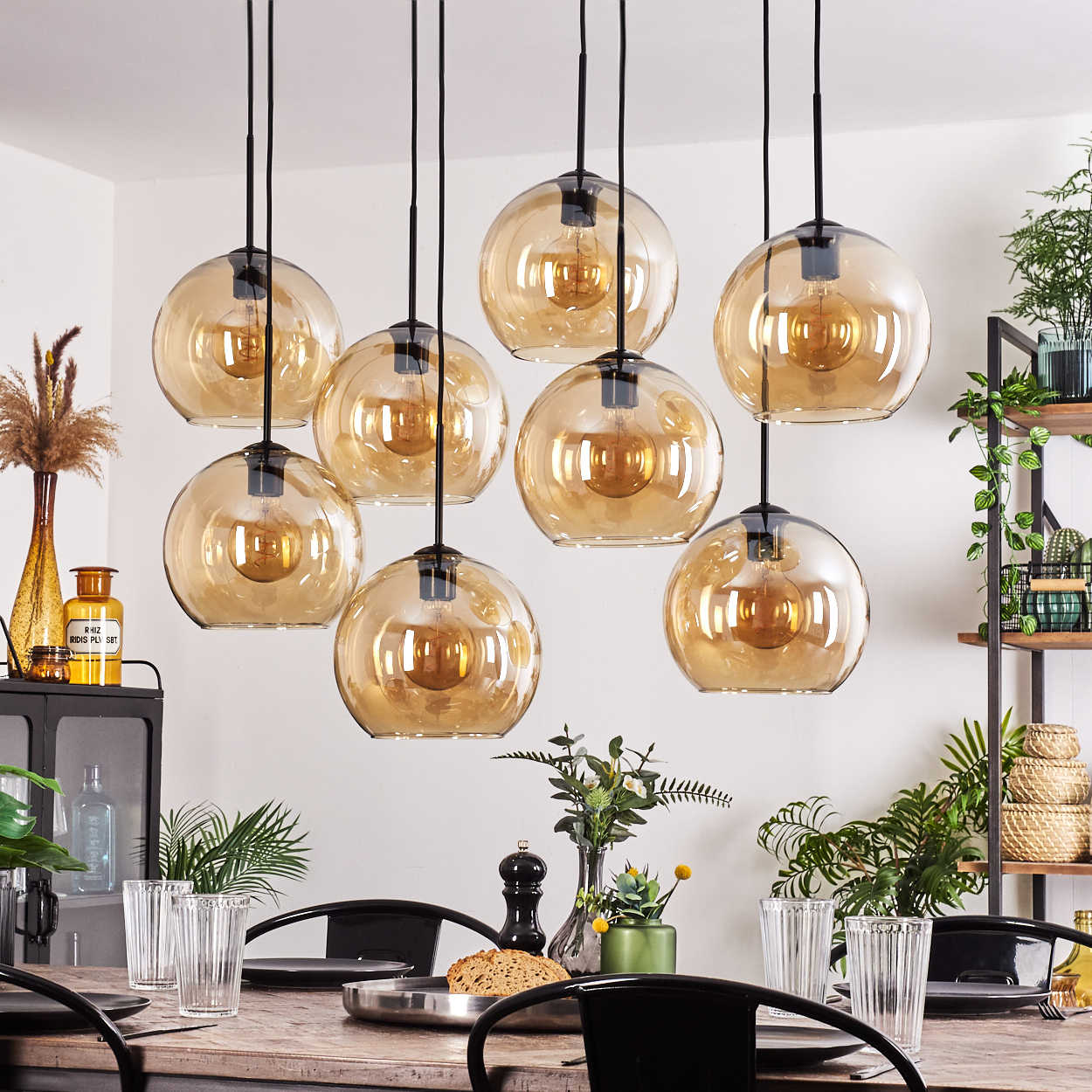 Esszimmer mit hängenden bernsteinfarbenen Glaskugelleuchten über einem Holztisch.