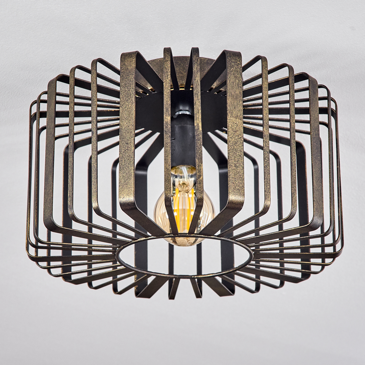 Deckenleuchte mit bronzefarbenem, käfigartigem Design. Eine Glühbirne ist innen sichtbar.