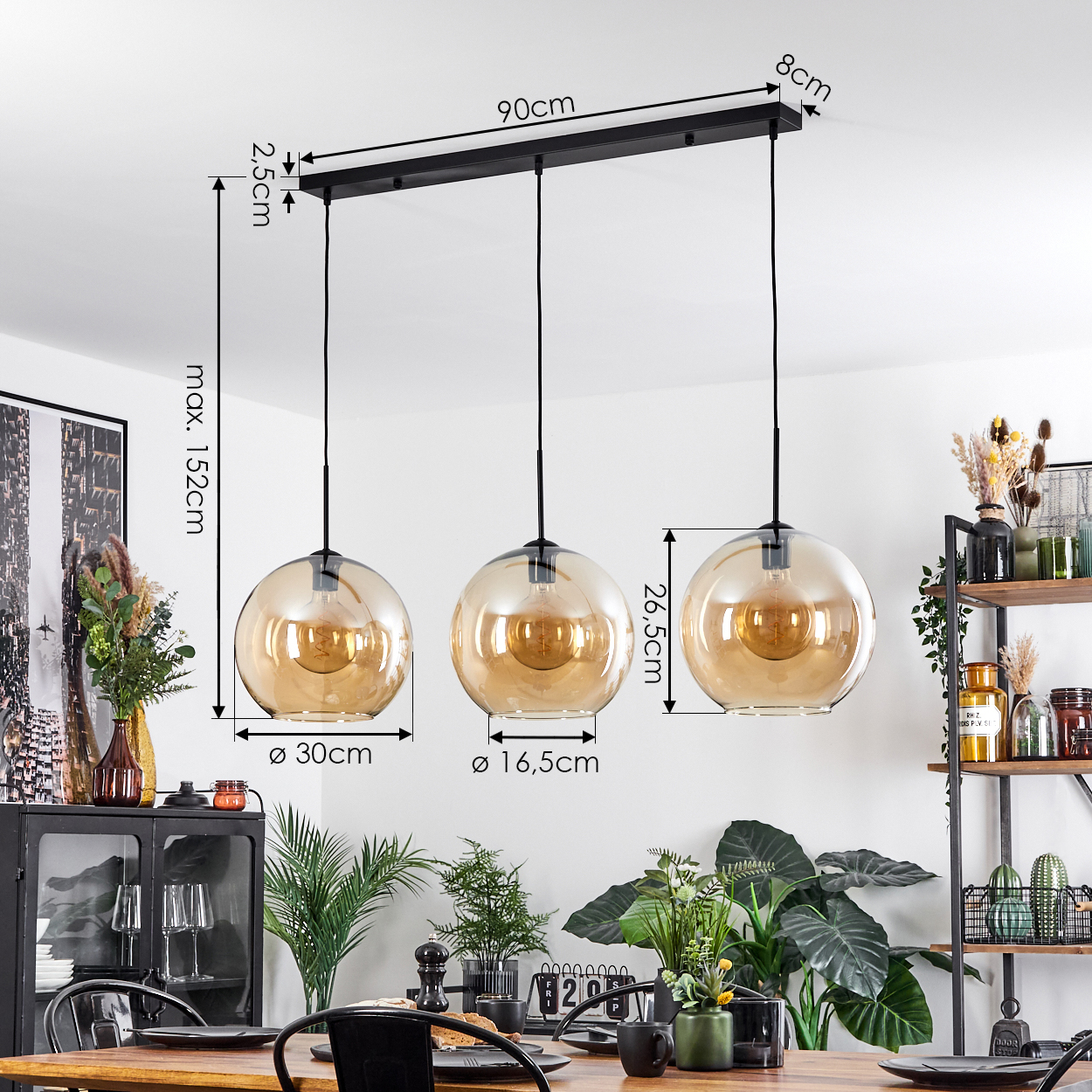 Drei Pendelleuchten mit bernsteinfarbenen Glaskugeln hängen über einem Tisch in einem Esszimmer.