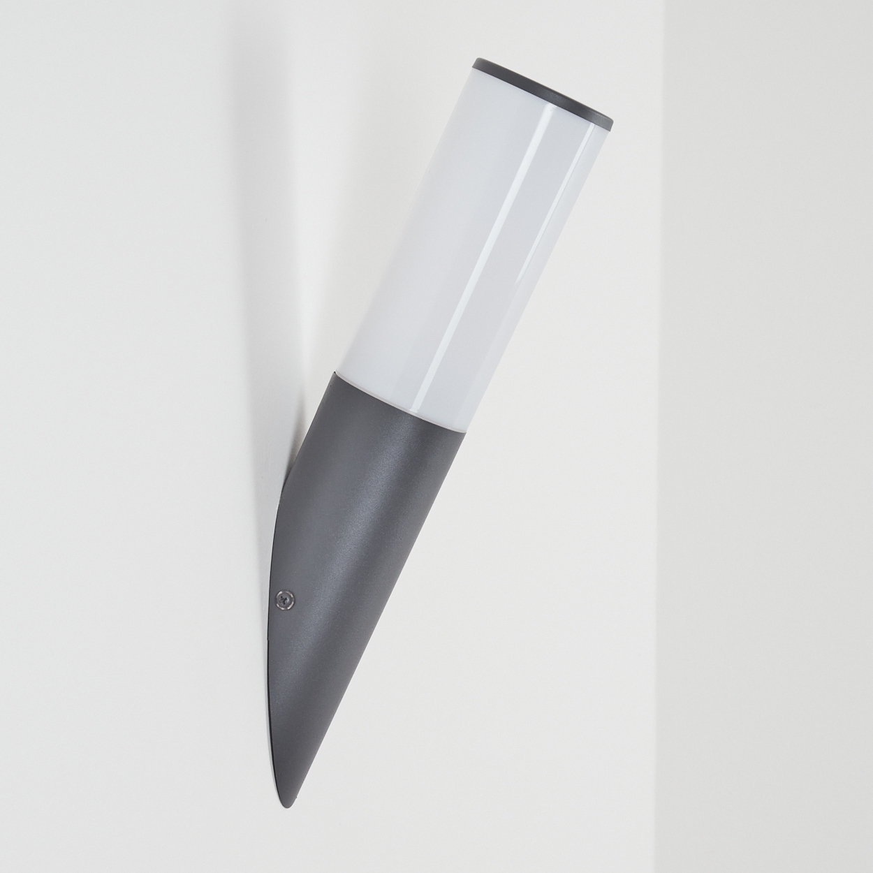 Angewinkelte, grau-weiße Wandleuchte. Zylindrisches Design mit leuchtendem Licht, an weißer Wand.