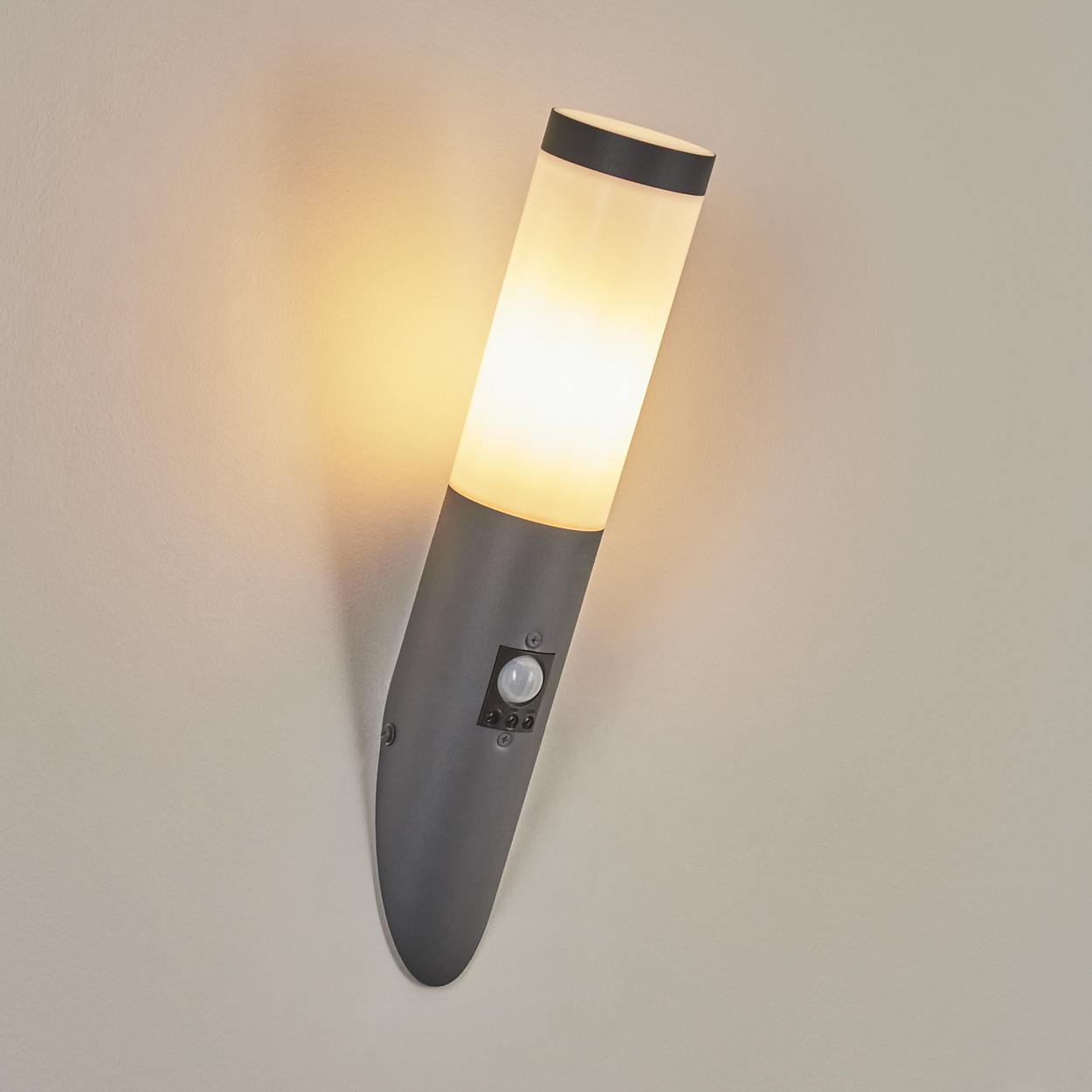 Graue Wandleuchte mit weißem Abschnitt. Sensor und Licht sind an.