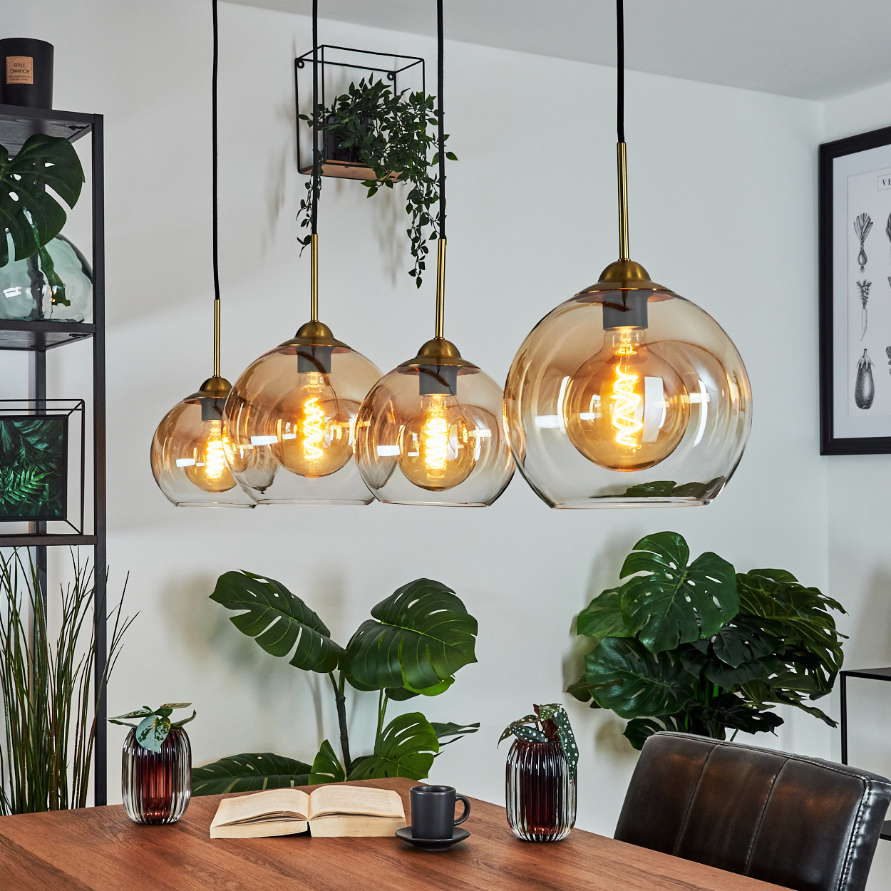 Innenraum mit vier Glas-Pendelleuchten über einem Holztisch, mit Pflanzen.