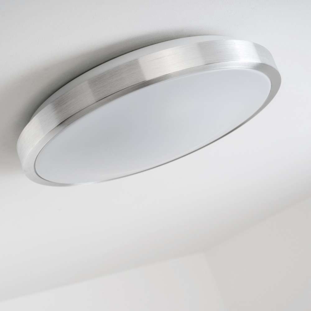 Deckenleuchte mit gebürsteter Metallverkleidung und weißem Diffusor.