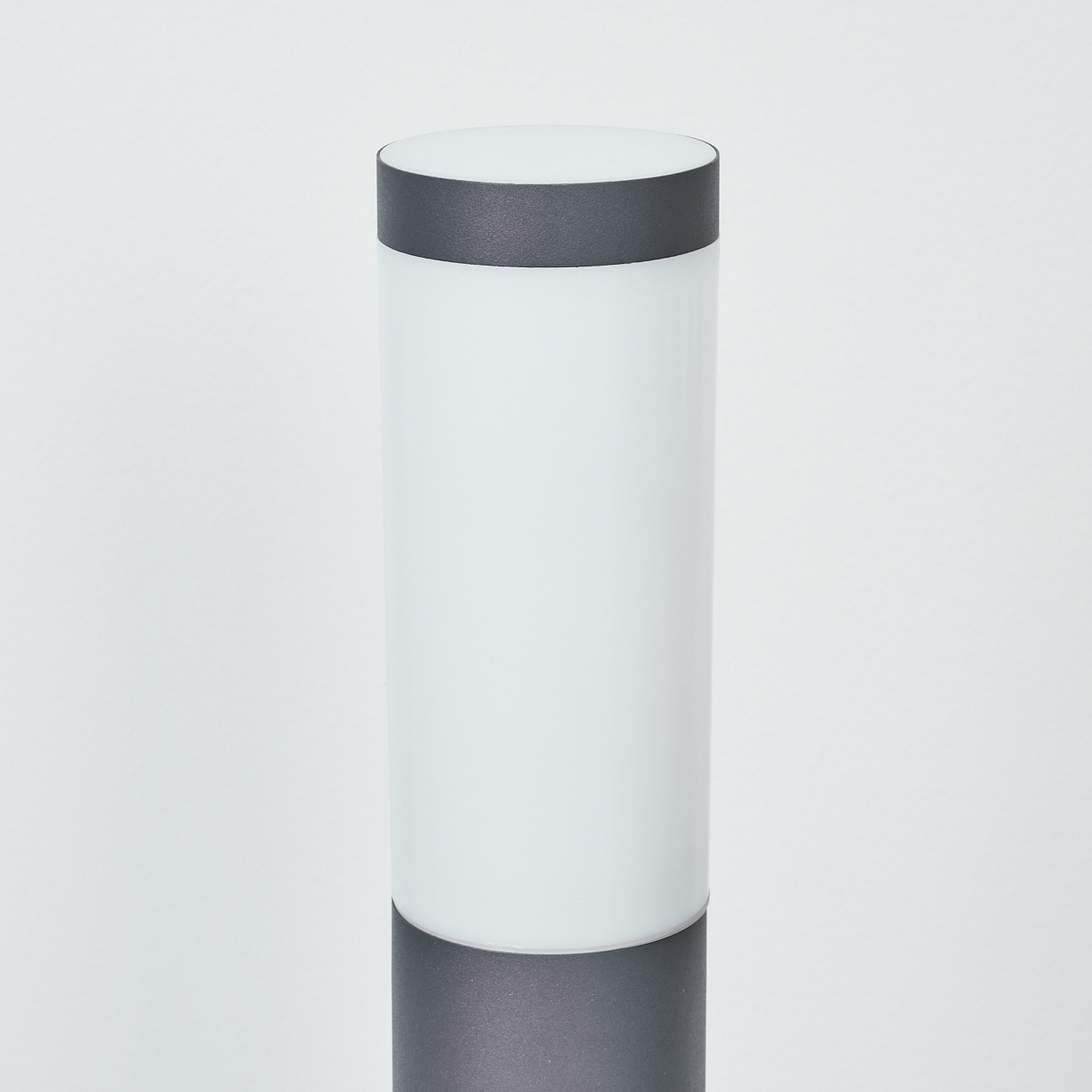 Zylindrische Lampe in Weiß und Grau, mit dunkelgrauem Ober- und Unterteil, isoliert.