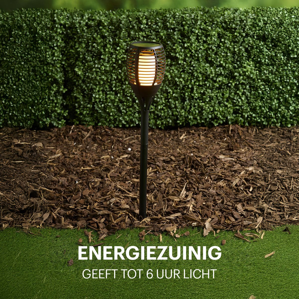 Black solar torch with a flame-like LED, set on mulch and green grass.