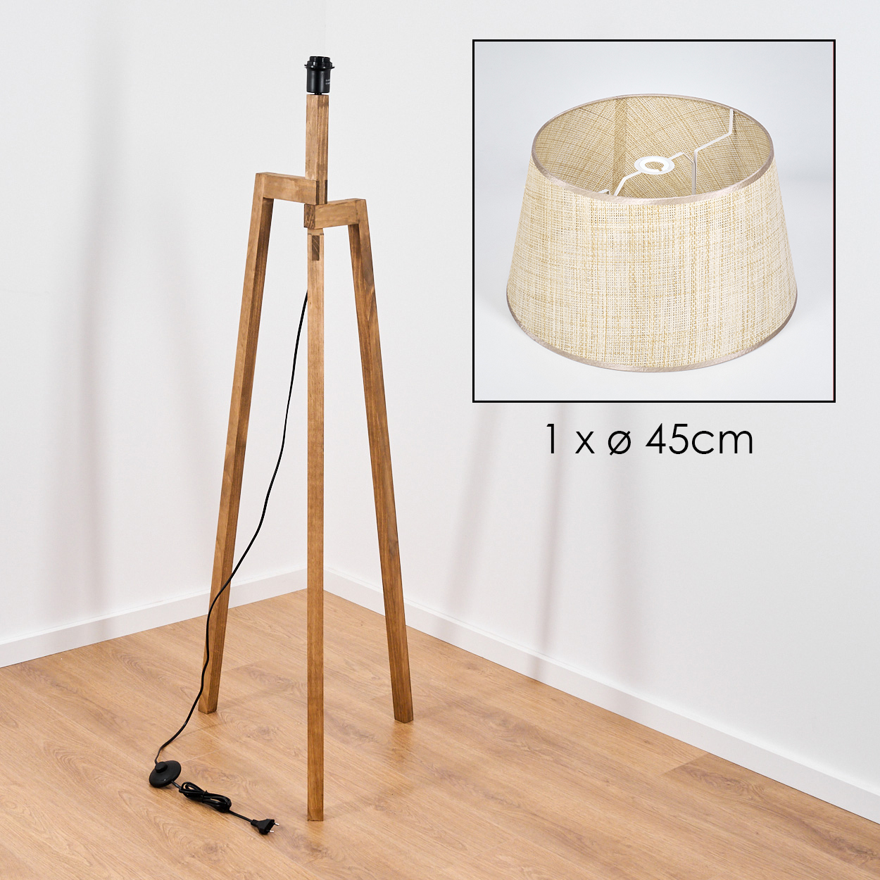 Holz-Stativ-Stehleuchte mit beigem Lampenschirm. Schwarzes Kabel und Stecker auf Holzfußboden.