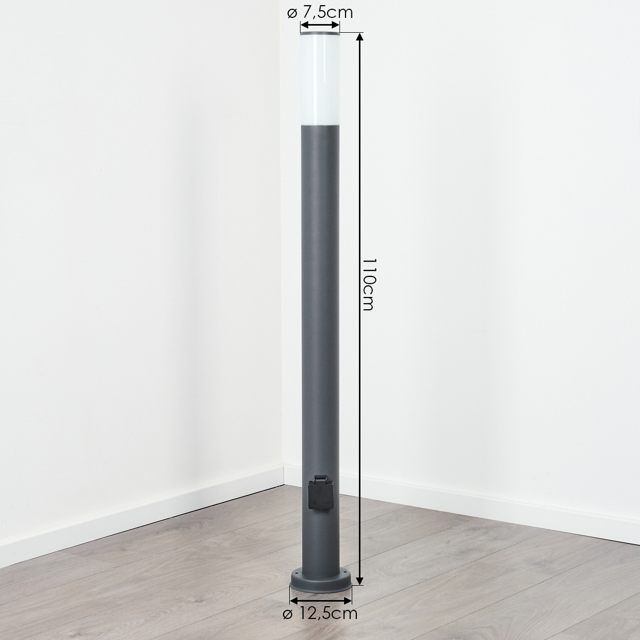 Hohe dunkelgraue Lampe mit weißem Oberteil, in einer Zimmerecke. Abmessungen sind angegeben.