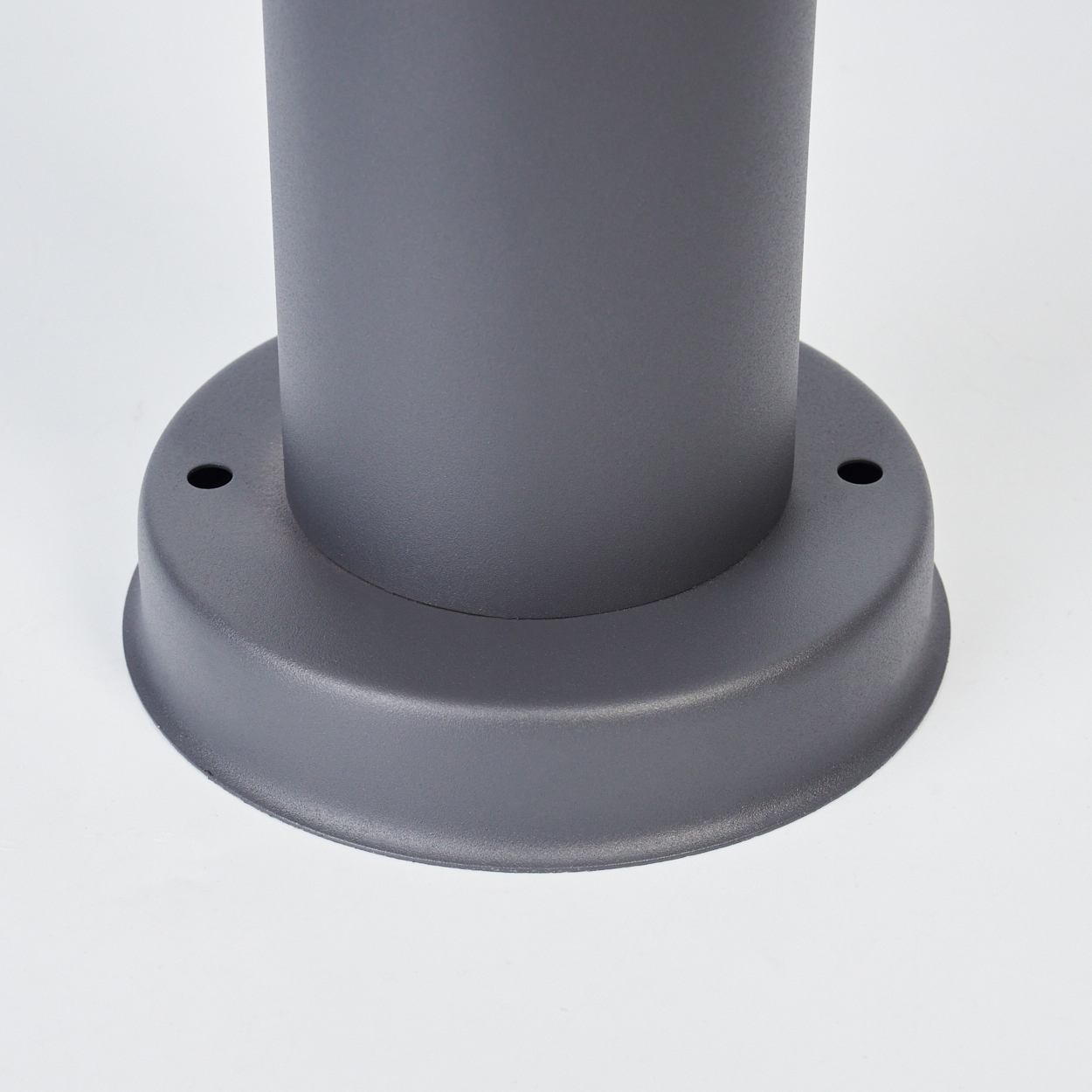 Der Sockel einer Außenlaterne. Der Sockel ist grau und hat zwei Löcher.