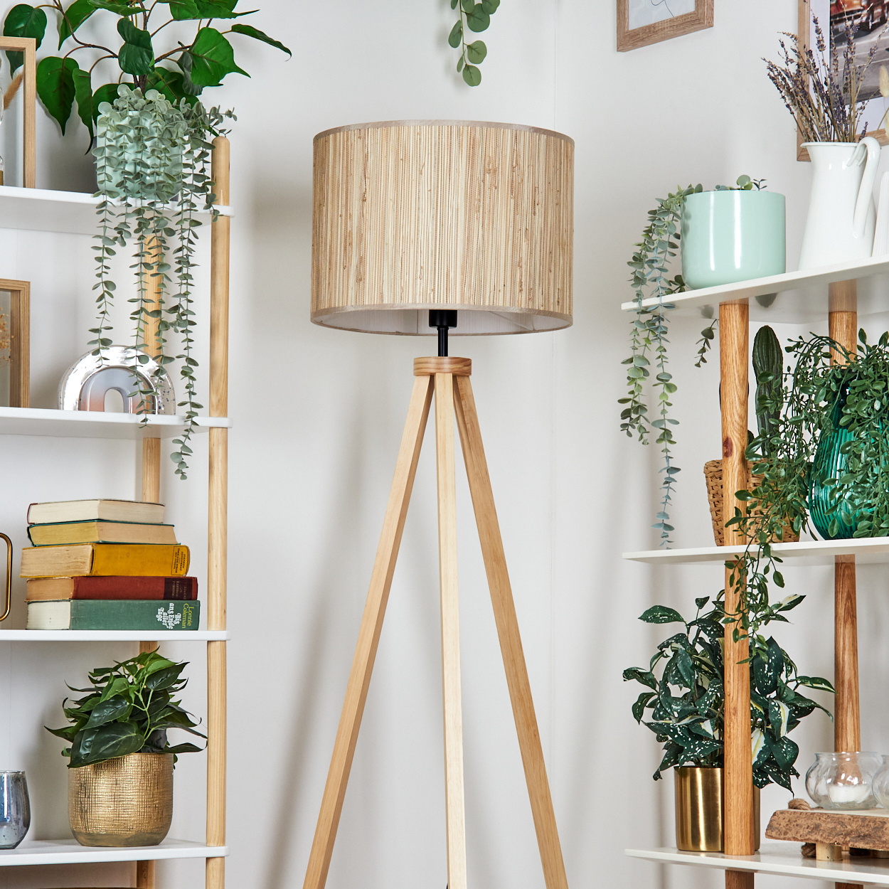 Holz-Stativ-Stehlampe mit gewebtem beigem Schirm. Pflanzen und Regale.