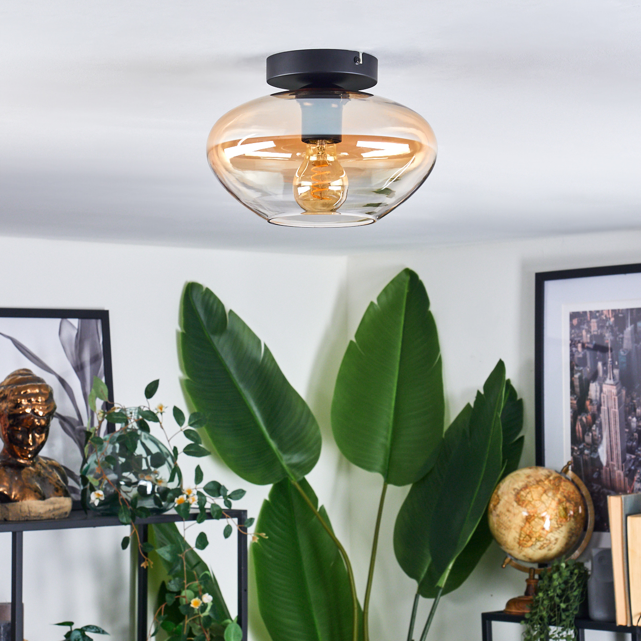 Deckenlampe mit bernsteinfarbenem Glasschirm, sichtbarem Leuchtmittel. Pflanzen, Kunst, Globus.