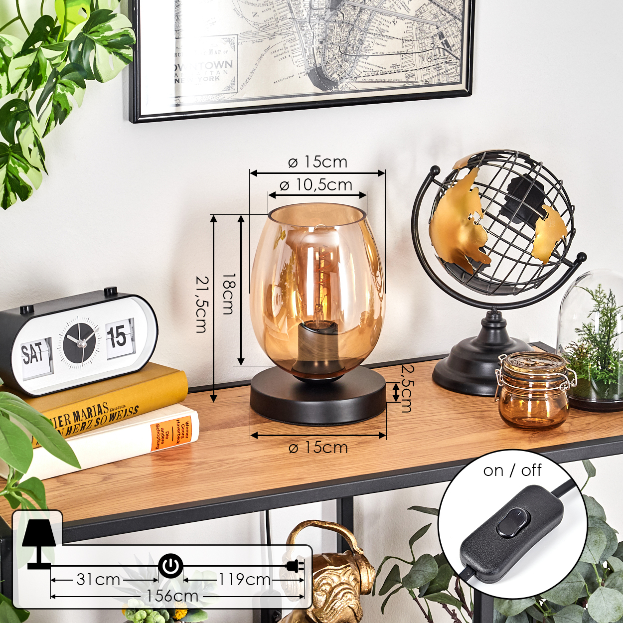Tischlampe mit bernsteinfarbenem Glasschirm. Bücher, Globus und Dekoration auf Holzregal. Schwarzer Rahmen.